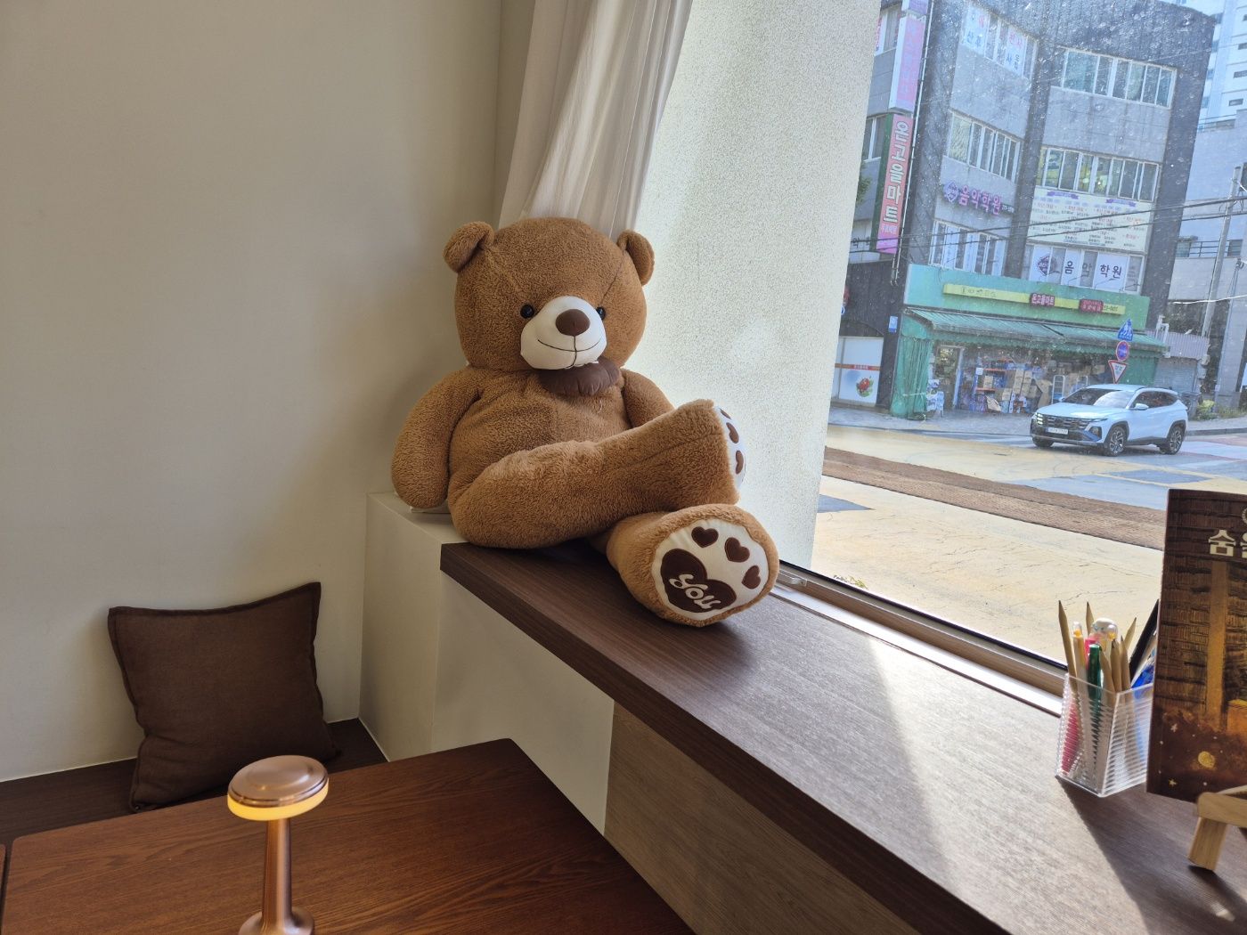 빠몽드 창가 자리에 앉아 있는 곰 인형